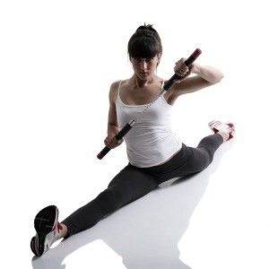 sport karate girl doing splits with nunchaku, fitness woman silhouette studio shot over white background